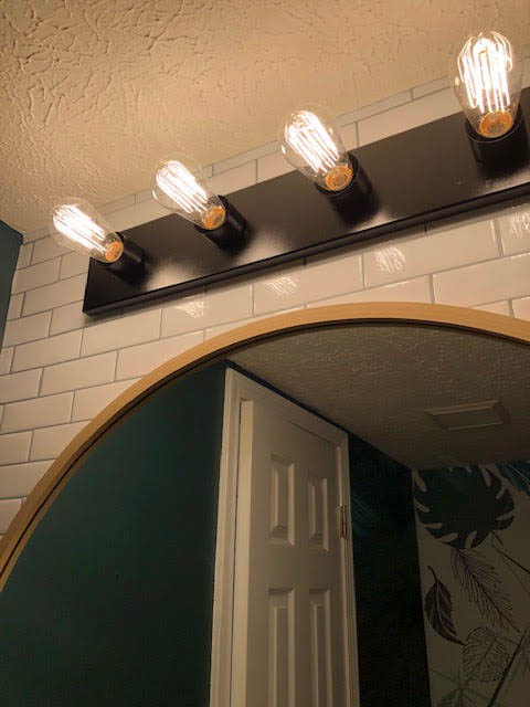 Builder grade bathroom light refreshed with black satin spray paint and vintage bulbs
